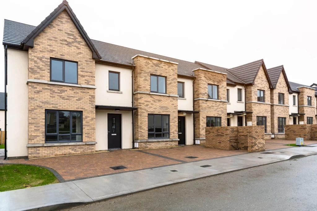 Modern brick townhouses with driveways on a suburban street, showcasing contemporary architecture.