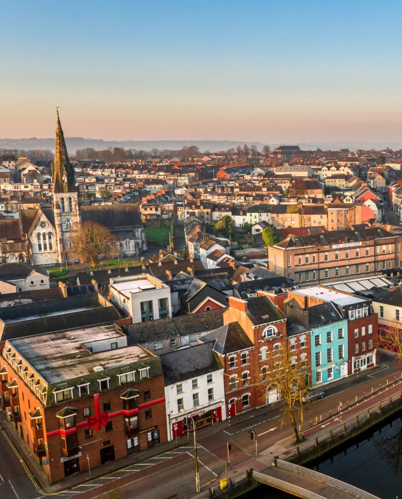Aerial view of a charming cityscape with historic church, colorful buildings, and clear blue sky.